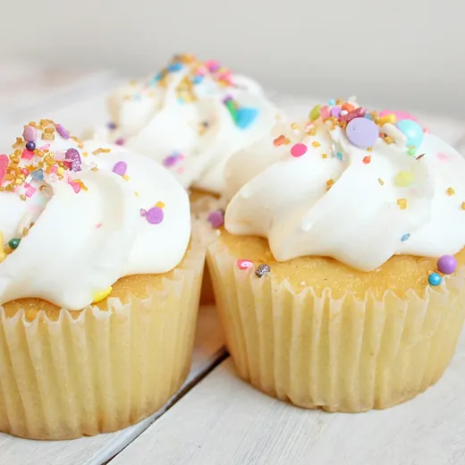 Vanilla cupcakes with swirled frosting and sprinkles